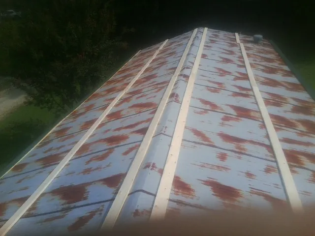 Rusted metal roof panels with new wood purlins before replacement — Storm Damage Roof Repair in Walsh by Roofing Brothers